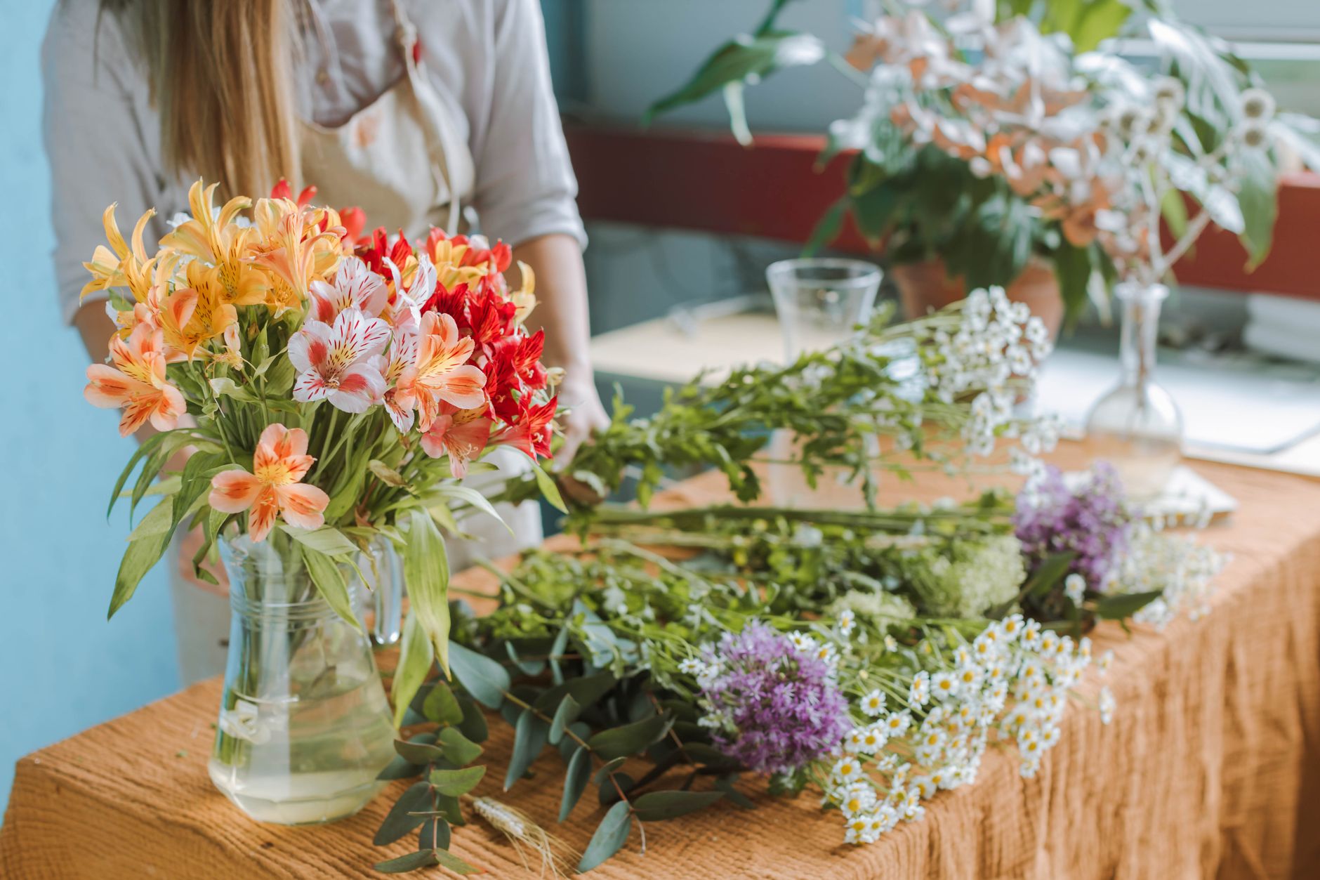 A representative bright floral workshop with orange, white, and green stems